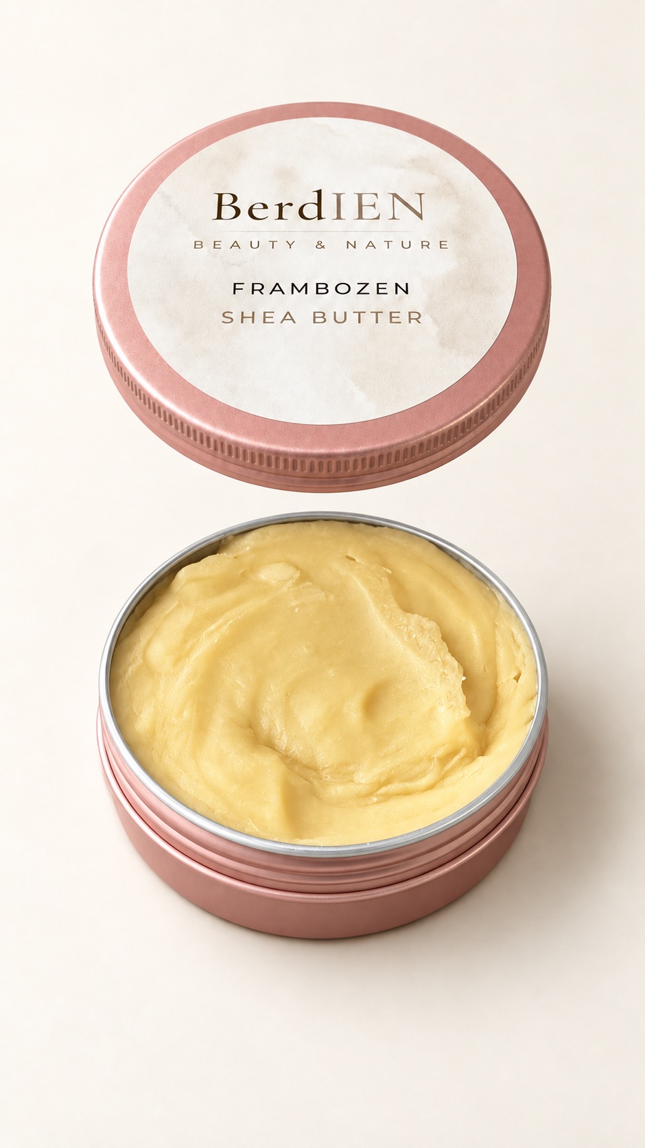 Geopend roze potje Frambozen Shea Butter met gele sheabutter en het deksel erboven
